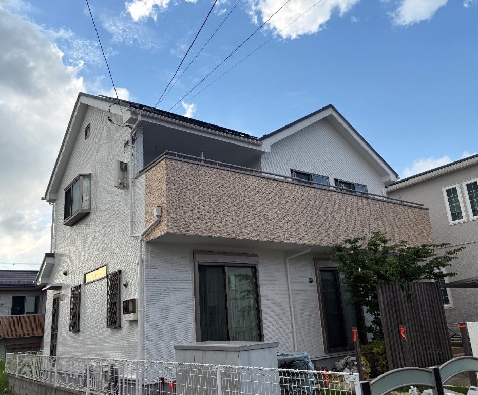 千葉市若葉区の戸建て住宅 外壁塗装・屋根カバー工法施工後の外観。ロックペイント ハイパーユメロック N-90の明るい外壁とWBアート仕上げのベランダ、横暖ルーフαSちぢみの屋根で清潔感と高級感がある仕上がり。